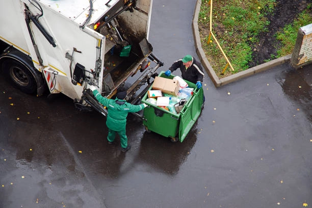 junk removal cre taking about to transfer junk from bin to truck to dispose it off
