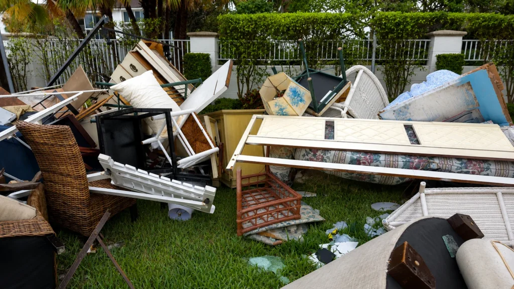 Pile of old broken furniture and mattresses in a Brockton MA yard ready for professional junk removal.